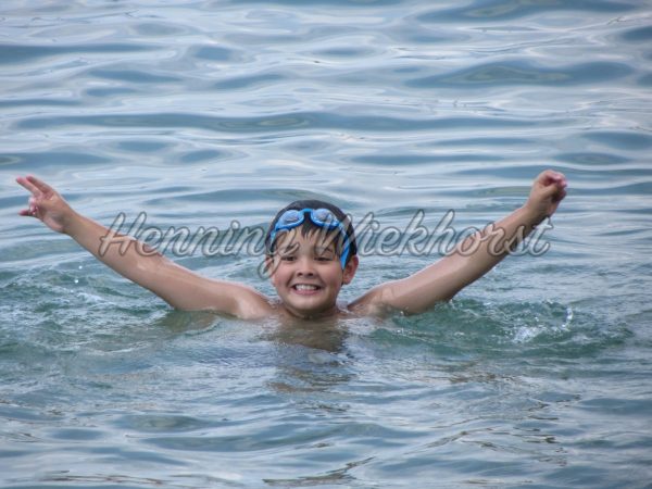 Fröhlich im Wasser schwimmender Junge - ImageShop